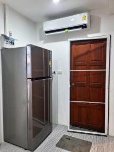 Ban Saiyuan (1)にあるPhujhaofa villa club ( ไสยวน)のキッチン(冷蔵庫付)、木製のドア