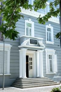 een wit huis met een bord dat horloges leest bij Twenties Hotel in Tbilisi City