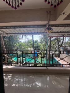 einen Balkon mit Poolblick in der Unterkunft Patil Homestay in Alībāg