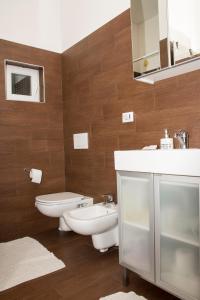 a bathroom with a sink and a toilet and a mirror at casa vacanza dovevai in Bergamo