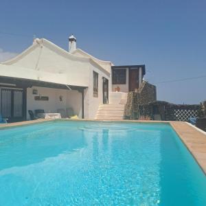 a swimming pool in front of a house at Islabella Lanzarote habitaciones en Villa con entrada particular in Tías