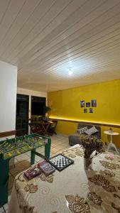 倫索伊斯的住宿－Tô em Casa，客厅配有桌子和黄色墙壁