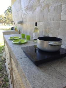- un comptoir avec un pot et une bouteille de vin dans l'établissement Bed & Breakfast Pintadera, à Santa Maria la Palma