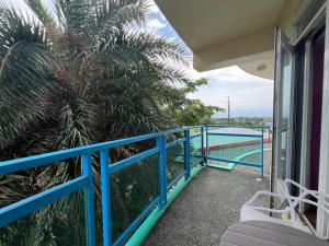 balcón con barandilla azul y palmera en The Riverview Retreats, en Wujie