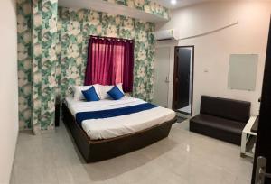 una camera con un letto e una sedia di Hotel Paradise Inn a Indore