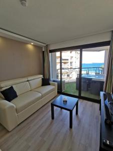 a living room with a couch and a table at Appartement en bord de mer in Cannes