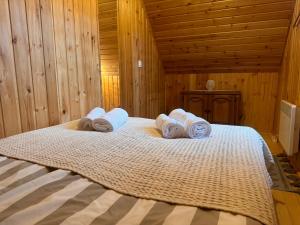 a bedroom with a bed with towels on it at Aproka - Chalet Mignon Adorable small guest house in Sicasău