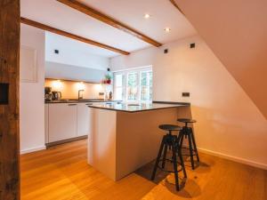eine Dachbodenküche mit Theke und Hockern in der Unterkunft Dream view Comfortable holiday residence in Kurort Bärenburg