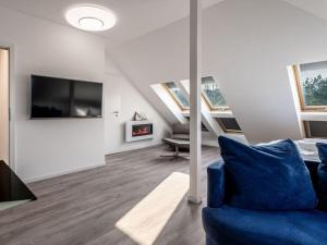 a living room with a blue couch and a tv at Water Comfortable holiday residence in Ostseebad Koserow