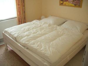 an unmade bed with white sheets and pillows at Picobello 2 Comfortable holiday residence in Timmendorfer Strand