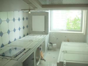 a white kitchen with a sink and a window at Picobello 2 Comfortable holiday residence in Timmendorfer Strand