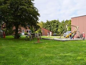 un parc avec une aire de jeux et une balançoire dans l'établissement Deichjuwel Comfortable holiday residence, à Norddeich