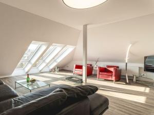 a living room with a couch and red chairs at Space Comfortable holiday residence in Ostseebad Koserow