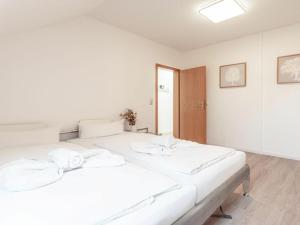 a white bedroom with a large bed with white sheets at Space Comfortable holiday residence in Ostseebad Koserow