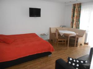 a bedroom with a bed and a table and a television at Ferienwohnung Fred in Hollersbach im Pinzgau