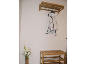 a coat rack hanging on a wall next to a stool at Deichstübchen Comfortable holiday residence in Norddeich
