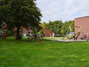 a park with a playground with a swing at Deichstübchen Comfortable holiday residence in Norddeich