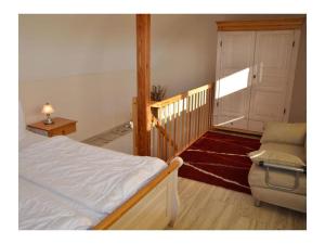 a bedroom with a bed and a door and a chair at Bella Casa 36 - Mones in Juliusruh