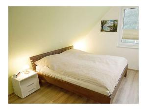 una camera con un letto, un comodino e una finestra di Seewind Comfortable holiday residence a Breege