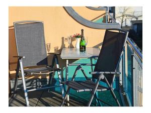 two chairs and a table on a balcony at Bella Casa 36 - Mones in Juliusruh