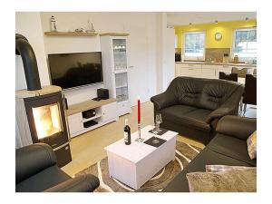 un soggiorno con due divani e una televisione di Seewind Comfortable holiday residence a Breege