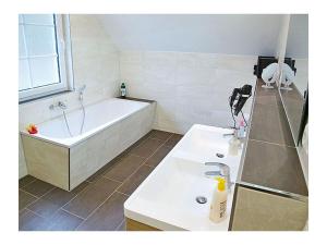 un bagno con una vasca bianca e un lavandino di Seewind Comfortable holiday residence a Breege Altre 12 foto