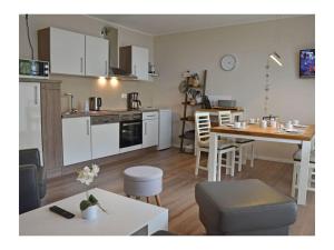 a kitchen and living room with a table and a dining room at Finn Comfortable holiday residence in Juliusruh