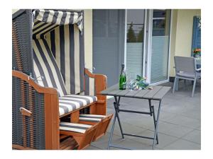 a patio with a table and a bottle of beer at Finn Comfortable holiday residence in Juliusruh