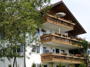 um edifício com varandas de madeira e flores em Alpine Lodge Comfortable holiday residence em Wertach