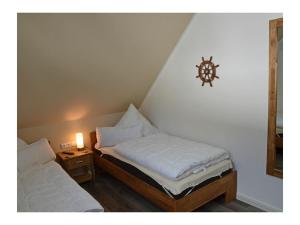 a bedroom with two beds and a lamp on a wall at Starfish Comfortable holiday residence in Breege
