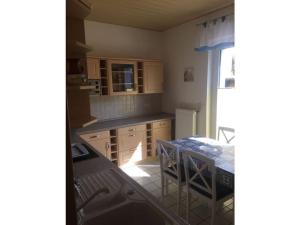 ヴァーレンにあるOn the Müritz lake shore, apartment 2のキッチン(木製のキャビネット、テーブル付)