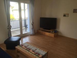 ヴァーレンにあるOn the Müritz lake shore, apartment 2のリビングルーム(薄型テレビ、テーブル付)