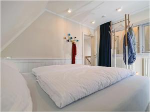 a bedroom with a large white bed in a room at By the sea Comfortable holiday residence in Dranske