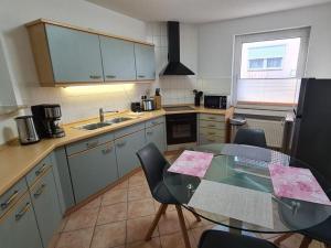 a kitchen with a glass table and a table and chairs at Earth Comfortable holiday residence in Ostseebad Koserow