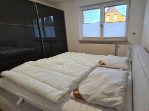 two unmade beds in a room with a window at Earth Comfortable holiday residence in Ostseebad Koserow
