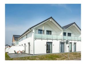 a white house with a balcony on top of it at Three-master house no 1 in Breege