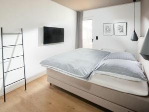 a bedroom with a bed and a flat screen tv at Mooi 3 Comfortable holiday residence in Norderney