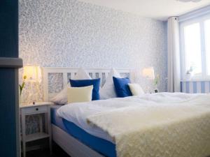 Dormitorio azul y blanco con cama y ventana en In the singer's house, a modern retreat en Ühlingen-Birkendorf