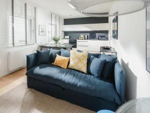 a blue couch in a living room with a kitchen at Mooi 3 Comfortable holiday residence in Norderney