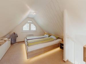 a attic bedroom with two beds and a window at Waldhaus Heidetraum Comfortable holiday residence in Sprakensehl