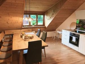 een keuken en eetkamer met een houten tafel en stoelen bij Böllenburg Comfortable holiday residence in Bernbeuren