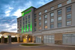 un edificio de hotel con un letrero verde. en Holiday Inn Detroit Northwest - Livonia, an IHG Hotel, en Livonia