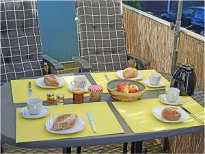 a table with plates of pastries and a bowl of fruit at Carlo Comfortable holiday residence in Juliusruh