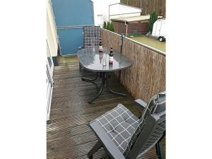 a table and chairs on a balcony with two bottles of beer at Carlo Comfortable holiday residence in Juliusruh