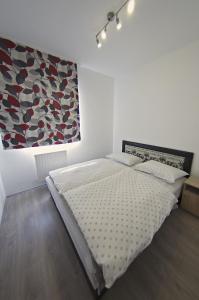 ein Schlafzimmer mit einem Bett und einem Wandgemälde in der Unterkunft Luca Apartman in Sopron