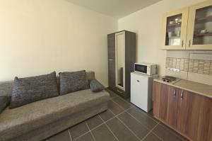 a living room with a couch and a kitchen at Luca Apartman in Sopron