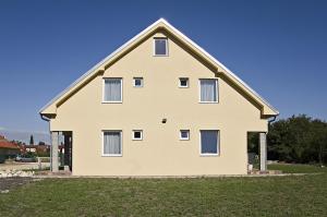 uma casa branca com um telhado de gambrel em Luca Apartman em Sopron