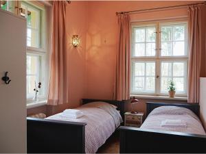 a bedroom with two beds and two windows at Villa Sommerfeld 