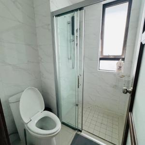 a bathroom with a toilet and a glass shower at Cozy 2B1R condo Forest City in Gelang Patah