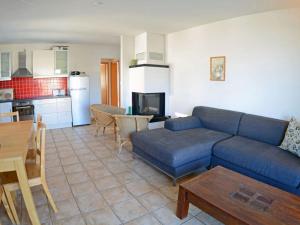 a living room with a blue couch and a kitchen at At the Dune Comfortable holiday residence in Juliusruh +11 photos